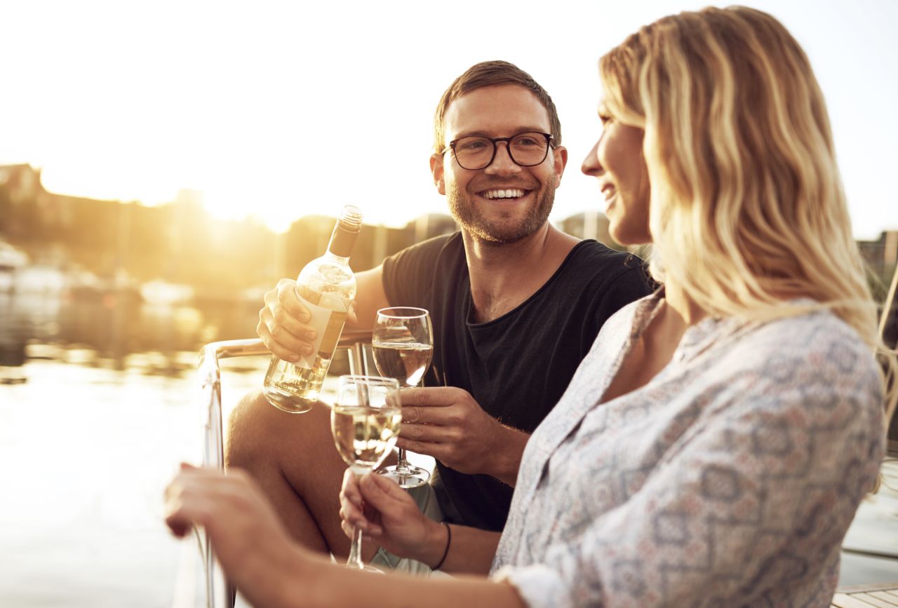 A couple drinking wine under a sunset