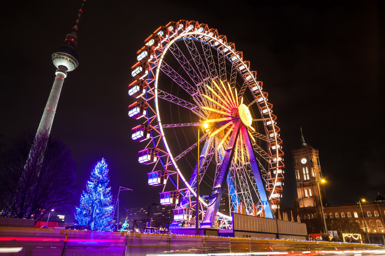 large ferris wheel in front of tv tower