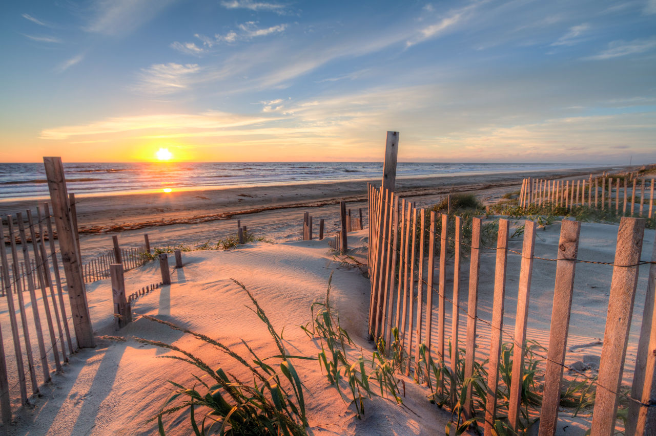A beach in Charleston with a romantic sunset in the background