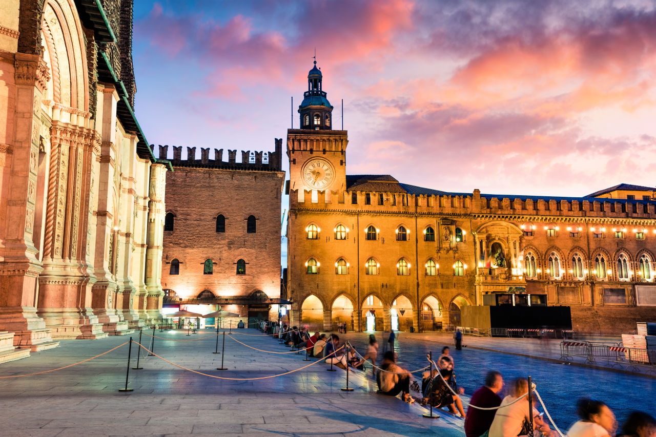 Colorful spring sunset on the main square of City of Bologna with Palazzo d'Accursio and facade of Basilica di San Petronio. Great cityscape of Bologna, Italy