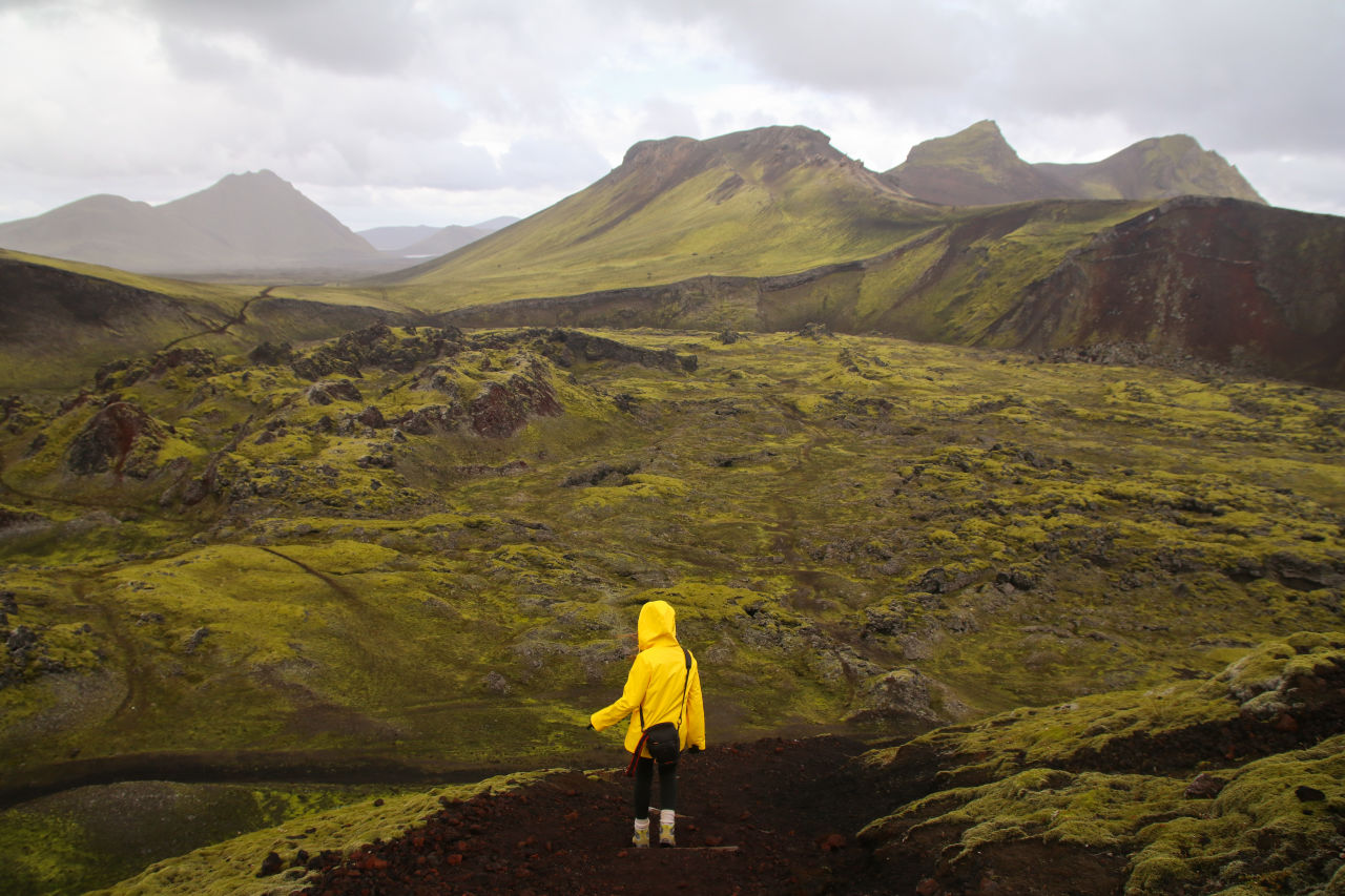 Icelandic landscape, person in yellow rain jacket. Landmannalaugar, Iceland.