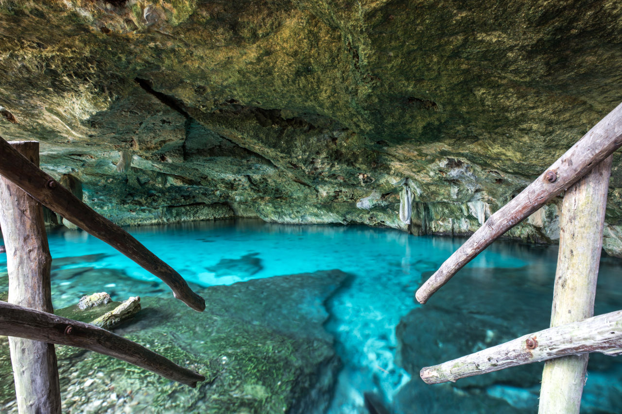 Steps leading down to a bright blue cenote