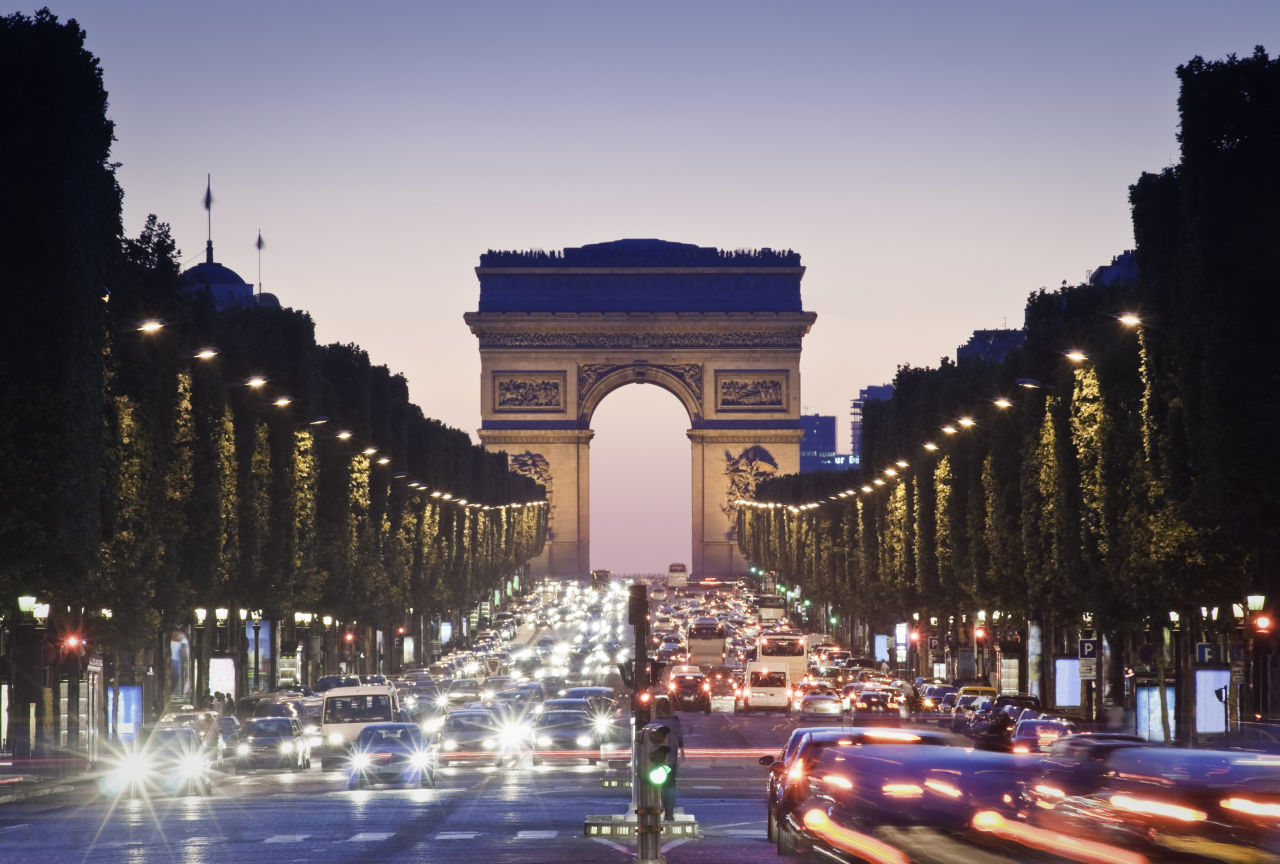 Road filled with cars leading to the Arc de Triomphe in Paris