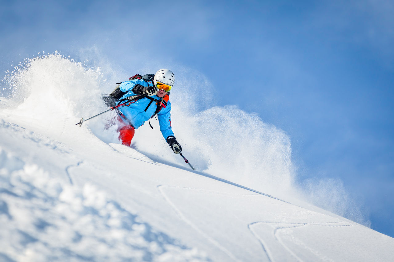 Eine Person fährt im Tiefschnee Ski.