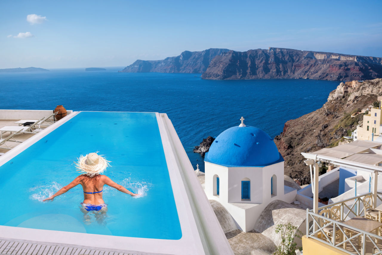 The Best Places to Travel Based on Your Birth Month - Woman in Santorini