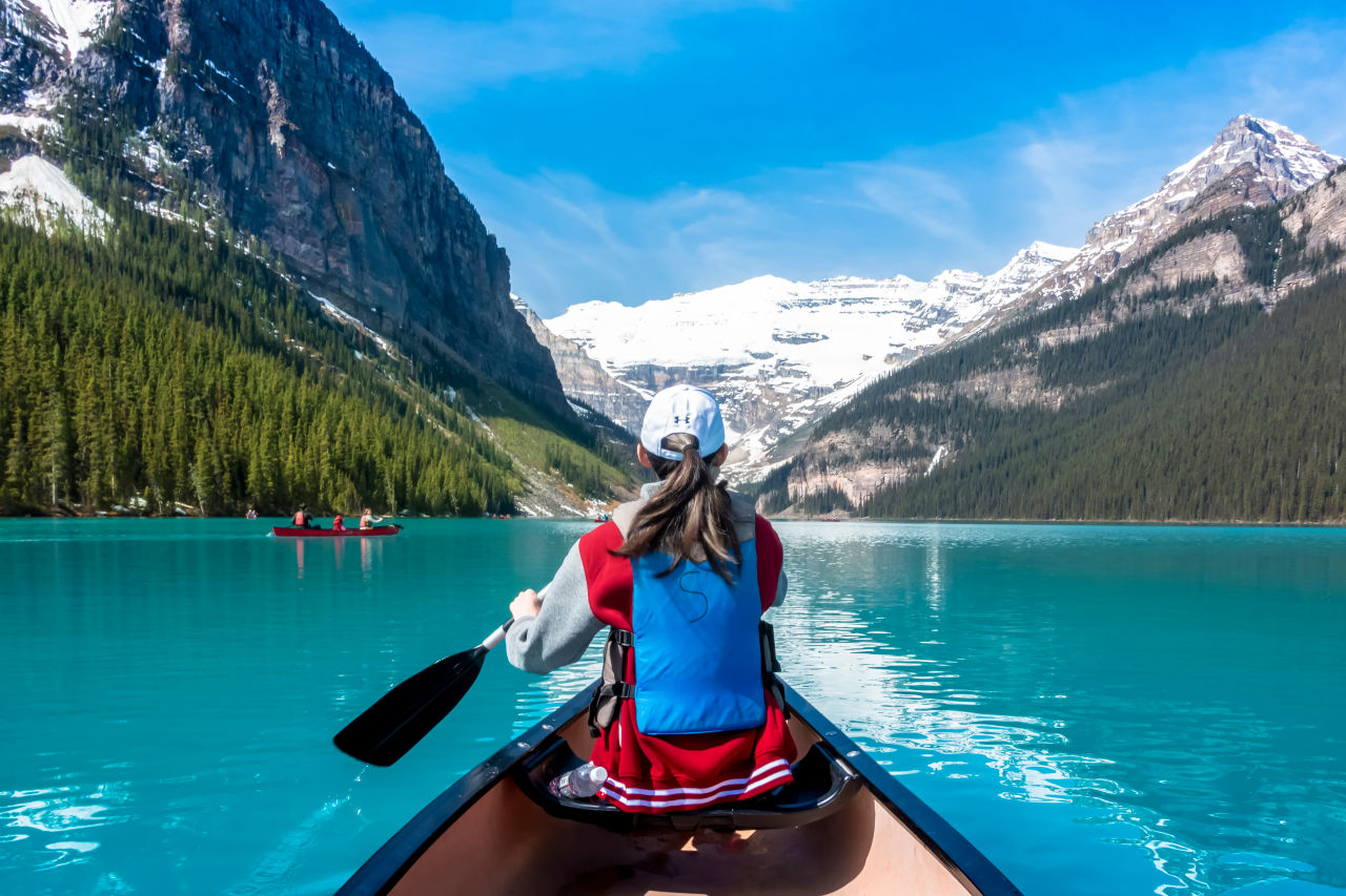 Frau fährt mit einem Kanu über den Lake Louise