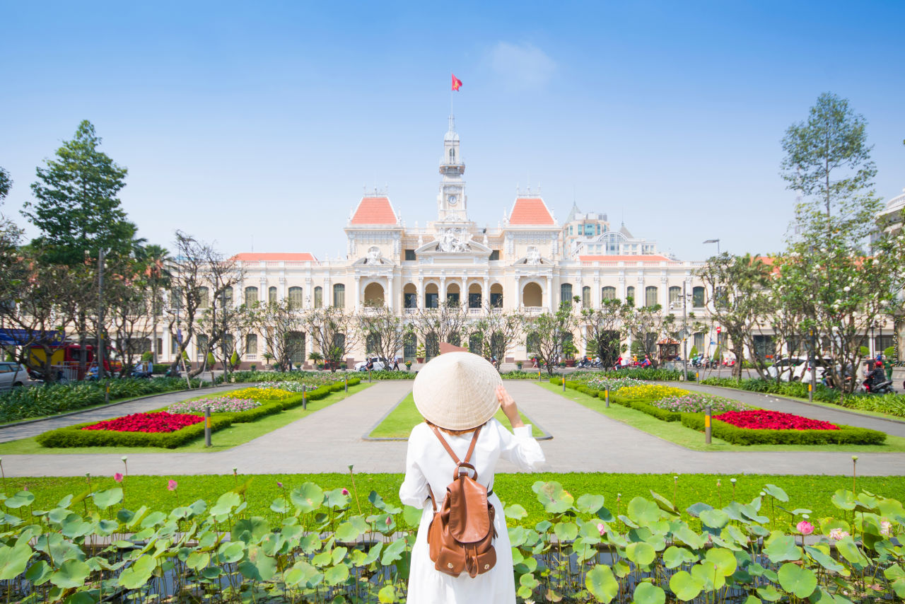 woman standing in front of ornate white building in Ho Chi Minh City