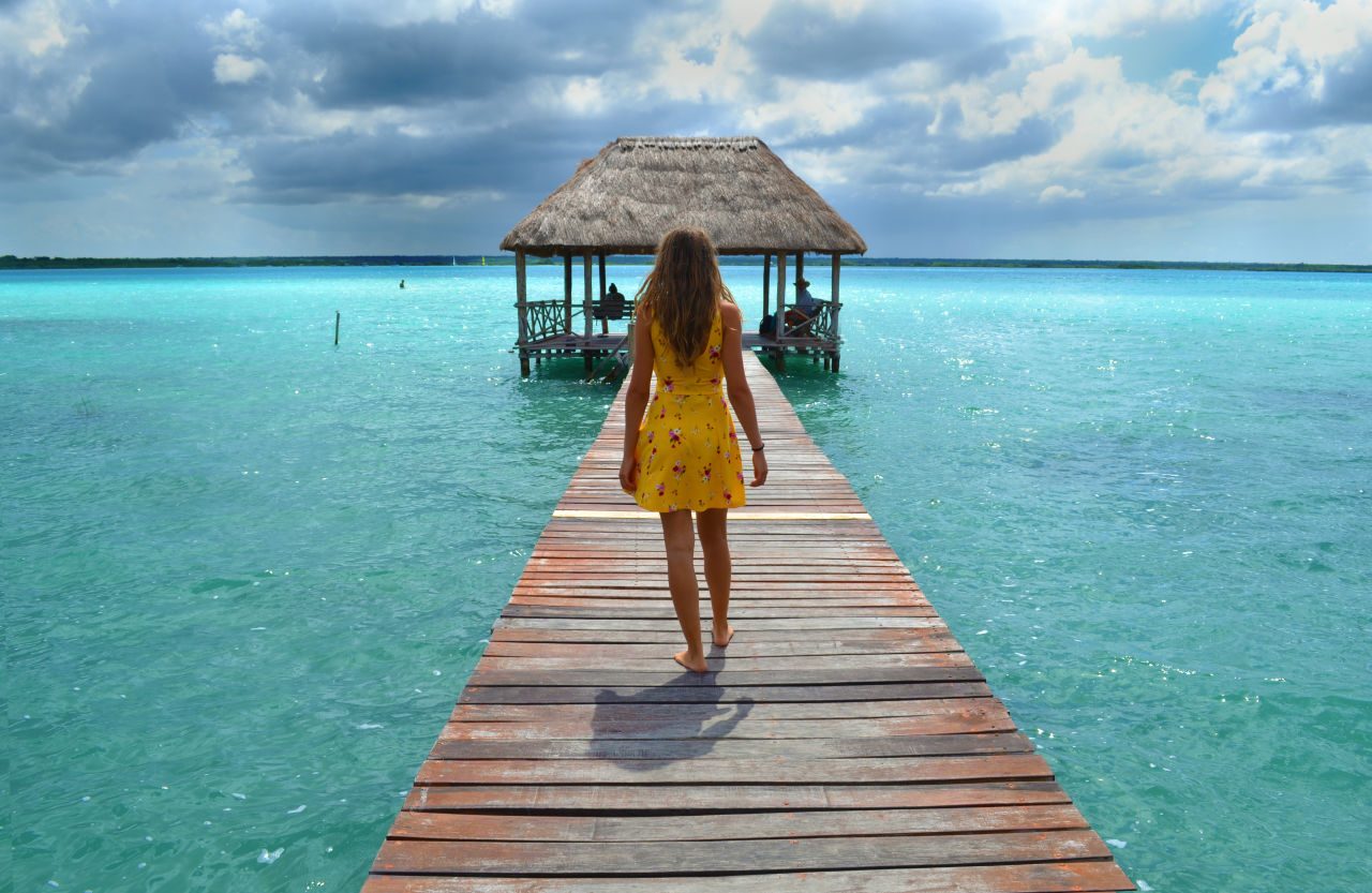 woman walking down a pier with water on either side