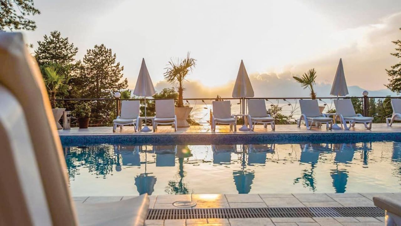 Zwembad met ligbedjes bij het Tino Sveti Stefan hotel in Noord-Macedonië