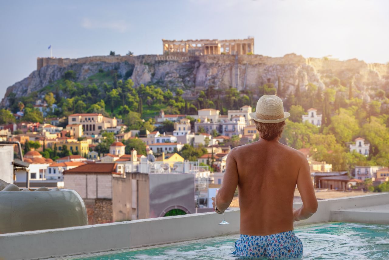 Tourist in Hotel Pool with Views of the Athens Acropolis in Greece