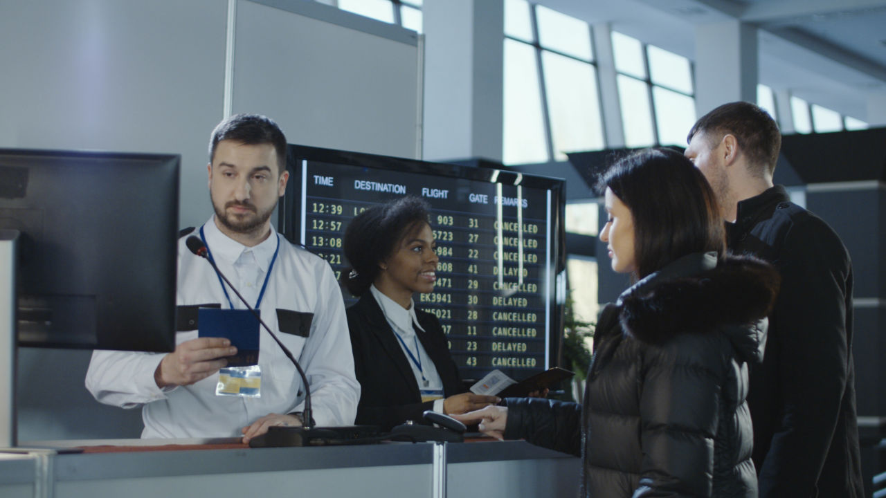 Couple going through airport security and scanning their fingerprints