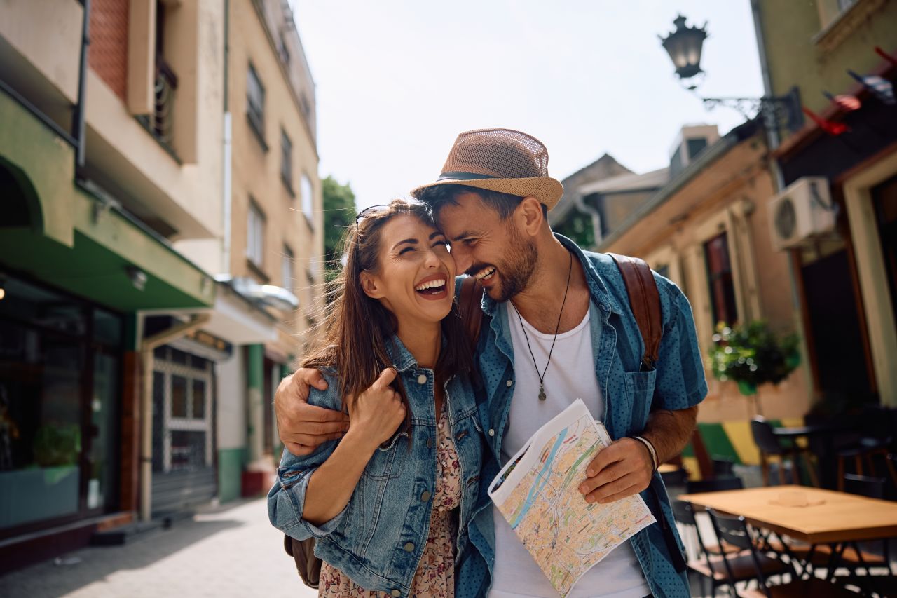 man and woman walking down street together smiling