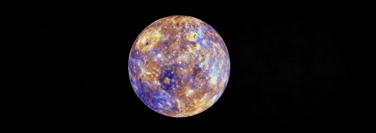 Color-enhanced image of the planet Mercury showing surface craters and mineral variations against a black background.