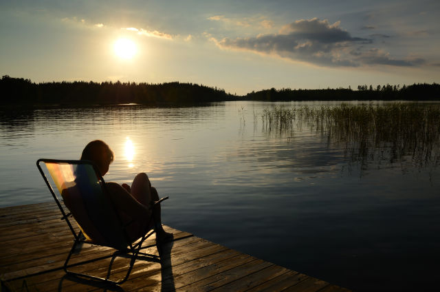 woman relaxing by a lake in Sweden