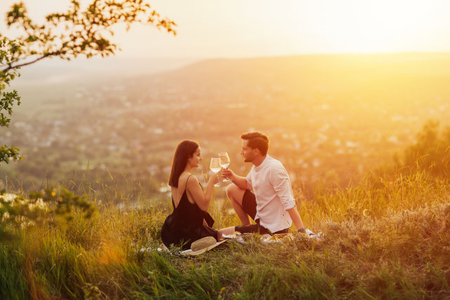 couple raising wine glasses during sunset
