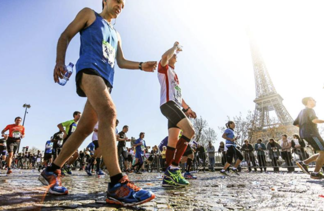Hardlopers die voor de Eifeltoren rennen tijdens de Marathon de Paris.