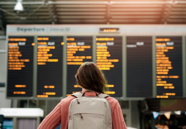 woman looking at reader board in airport