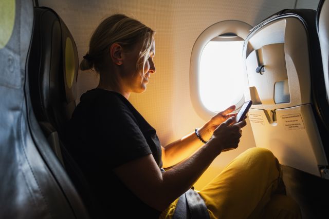 woman on cellphone on plane