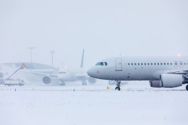 Thousands of Flights Canceled as Winter Storm Fern Grounds U.S. Travel - Plane sits in snow on Tarmac