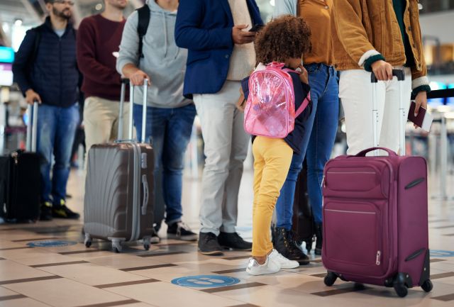 Reizigers in de rij op Schiphol door drukte.