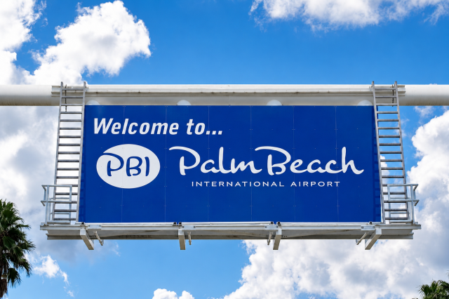 Welcome sign for Palm Beach International Airport (PBI) against a bright blue Florida sky before the proposed airport renaming discussion.