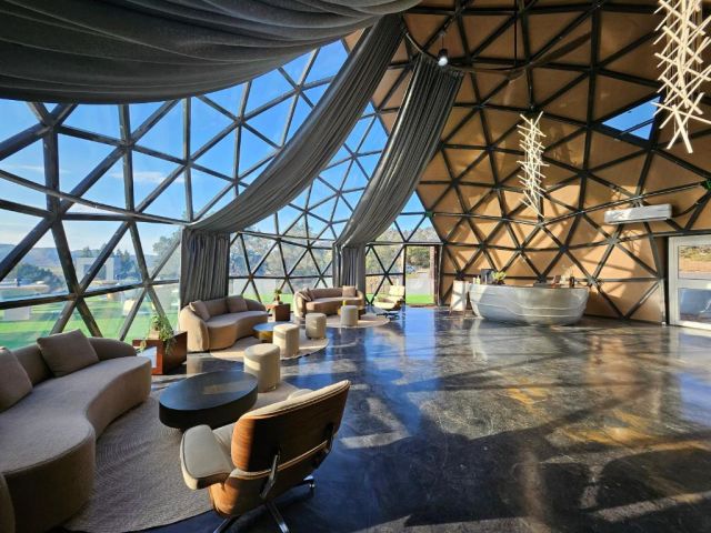 Clear Sky Resorts Bryce Canyon glass dome interior with panoramic windows, modern lounge seating, and views of the Utah canyon landscape