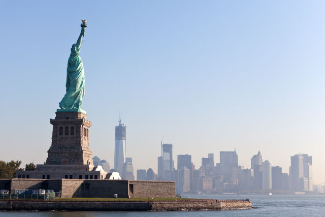 Statue of Liberty with the Manhattan skyline in the distance on a clear day